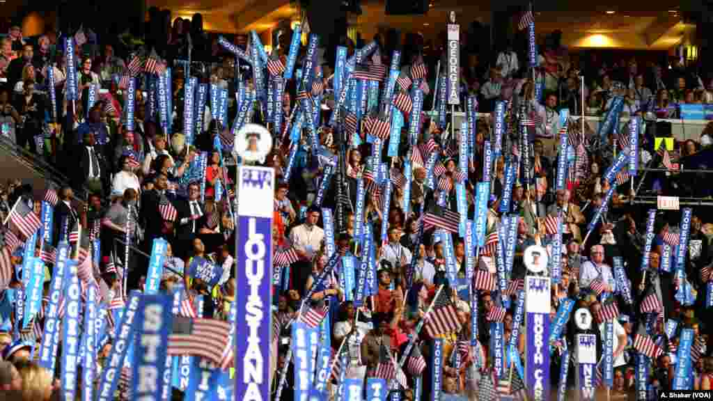 Delegates and convention attendees hold signs and wave flags during Hillary Clinton's speech on the final night of the Democratic National Convention in Philadelphia, July 28, 2016 (A. Shaker/VOA)