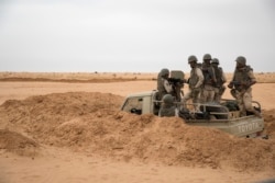 FILE - Soldiers of the Mauritania army wait in an armed vehicle at a G5 Sahel task force outpost in the southeast of Mauritania, along the border with Mali, Nov. 22, 2018.