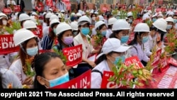 Medical students wearing face masks hold placards as they gather during an anti-coup protest in Mandalay, Myanmar, Feb. 21, 2021.