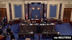 FILE - U.S. House lead impeachment manager Jamie Raskin, D-MD, hands over the House article of impeachment against former President Donald Trump, on the floor of the Senate in this this frame grab from video shot at the Capitol, Jan. 25, 2021.