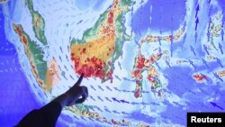 An officer points to fires or hot spots in Kalimantan, Indonesian part of Borneo, on a screen at the Fire Command Post at the Ministry of Environment and Forestry in Jakarta, Sept. 22, 2015 in this photo taken by Antara Foto. 