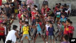 FILE - Children who traveled with their families from Venezuela play at the shelter in Arauquita, Colombia, March 25, 2021, on the border with Venezuela.
