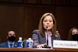 Supreme Court nominee Amy Coney Barrett tests her microphone during her confirmation hearing before the Senate Judiciary Committee, Capitol Hill in Washington, Oct. 14, 2020.