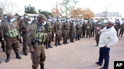 In this photo supplied by the Mozambican Presidency, President Filipe Nyusi, right, during a visit to his Defence and Security Force Troops in Northern Mozambique, July 9, 2021.
