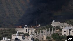 Smoke fills the sky after Israeli settlers set fire to the properties of Palestinian villagers in the West Bank village of al-Mughayyir, Saturday, April 13, 2024. 