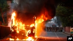 A passenger bus goes up in flames during a protest against the Citizenship Amendment Act in New Delhi, India, Dec. 15, 2019. 