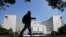FILE - A man walks past the headquarters of the People's Bank of China, the central bank, in Beijing, China, Sept. 28, 2018. 