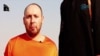 An image grab taken from a video released by the Islamic State (IS) and identified by private terrorism monitor SITE Intelligence Group purportedly shows U.S. freelance writer Steven Sotloff dressed in orange and on his knees in a desert landscape speaking to the camera before being beheaded by a masked militant (R).
