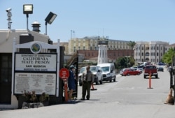 FILE - A Department of Corrections officer guards the main entryway leading into San Quentin State Prison in San Quentin, Calif., July 24, 2019.