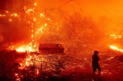 Bruce McDougal prepares to defend his home as the Bond Fire burns though the Silverado community in Orange County, California, Dec. 3, 2020.