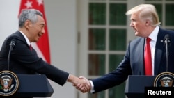Singapore's Prime Minister Lee Hsien Loong and U.S. President Donald Trump shake hands before giving joint statements in the Rose Garden of the White House in Washington, Oct. 23, 2017.