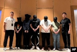 ภาพจากสำนักข่าวซินหัวแสดงให้เห็นเจ้าหน้าที่ตำรวจเมียนมานำส่งตัวผู้ต้องสงสัยคดีหลอกลวงทางอินเทอร์เน็ตและออนไลน์ 5 คน ให้กับตำรวจจีน ที่สนามบินนานาชาติย่างกุ้ง เมื่อ 26 ส.ค. 2567