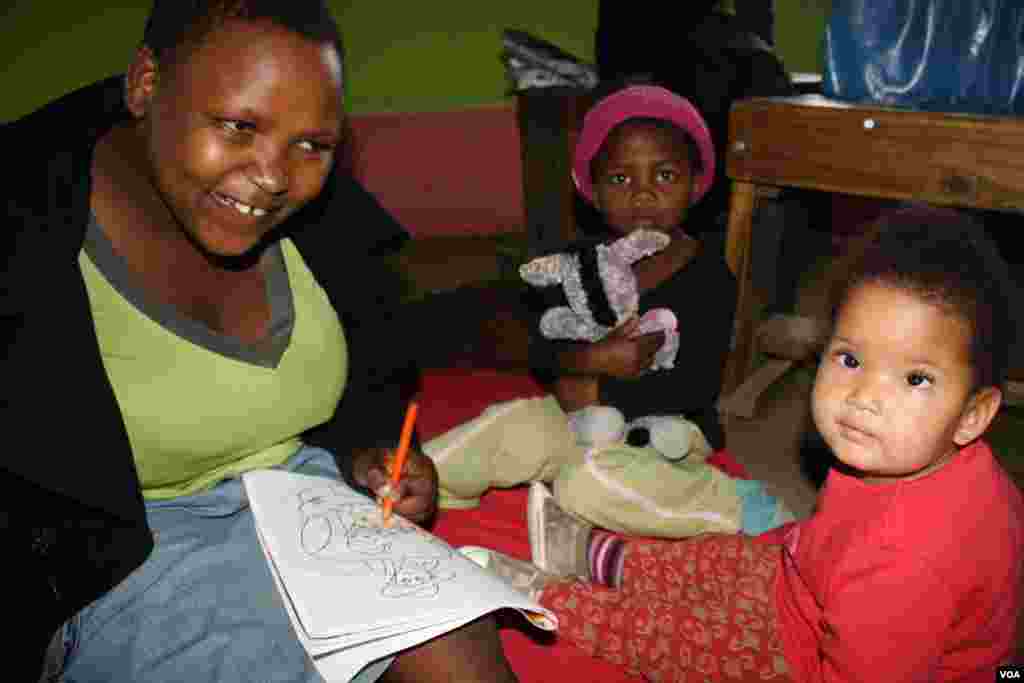 Some residents of Ikhaya Loxolo color in, in an atmosphere of love and acceptance (VOA/Taylor) 