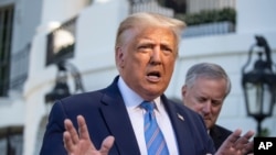 President Donald Trump speaks with reporters as he walks to Marine One on the South Lawn of the White House, July 29, 2020, in Washington.