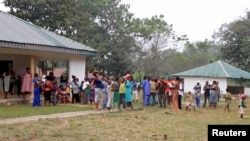 FILE - Cameroonian refugees stand outside a center in Agbokim Waterfalls village, which borders on Cameroon, in Nigeria, Dec. 9, 2017. A new study is tracking young rape victims and abortion since the start of Cameroon's separatist conflict.