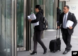 Members of the team of ousted Venezuelan prosecutor general Luisa Ortega carry evidence into the International Criminal Court denouncing President Maduro for crimes against humanity, in The Hague, Netherlands, Nov. 16, 2017.