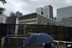 A man carries an umbrella past the U.S. Consulate in Guangzhou in south China's Guangdong province, June 7, 2018.