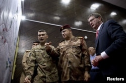 U.S. Defense Secretary Ash Carter, right, and Iraqi Lt. Gen. Abdul Amir al-Lami, center, look over diagrams and maps at the Combined Joint Operations Center in Baghdad, Iraq, July 23, 2015.