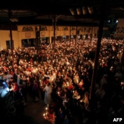 Người Công giáo cầm nến cầu nguyện cho tiến sĩ Cù Huy Hà Vũ tại nhà thờ Thái Hà ở Hà Nội, 02/04/2011