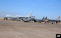 FILE - Turkish, right, and German, left, airmen stand in front of military planes at the Incirlik Air Base near Adana, Turkey, Dec. 15, 2015.
