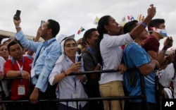 People take pictures as Pope Francis arrives at Tocumen international airport in Panama City, Jan. 23, 2019.