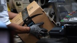 FILE - A worker assembles a box for delivery at the Amazon fulfillment center in Baltimore, Maryland, April 30, 2019.