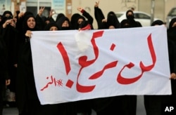 Bahraini protesters carry a banner reading, "We will not bow! #alNimr," during a demonstration against Saudi Arabia's execution of Shiite cleric Sheikh Nimr al-Nimr, in Daih, Bahrain, Jan. 2, 2016.