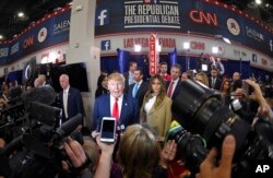 FILE - Donald Trump is joined by his wife, Melania, in the spin room following the CNN Republican presidential debate in Las Vegas, Dec. 15, 2015.