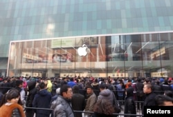 FILE - Customers wait for the opening of an Apple store in Shenyang, Liaoning province, Feb. 28, 2015.