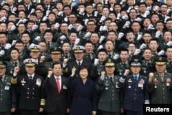 FILE - South Korean President Park Geun-Hye cheers with new military officers during a military commissioning ceremony at Gyeryongdae, South Korea's main military compound, March 4, 2016