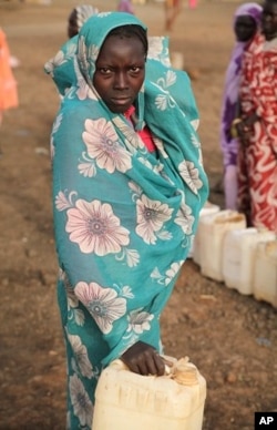 A woman leaving water point with empty jerry can - fights are common as desperation sets in