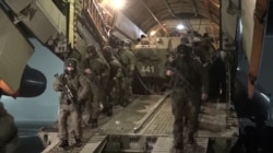 Russian service members disembark from a military aircraft, as part of a peacekeeping mission of the Collective Security Treaty Organisation amid mass protests in Almaty and other Kazakh cities, at an airfield in Kazakhstan, in this still image from video