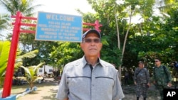FILE - Philippine Defense Secretary Delfin Lorenzana tours the Philippine-claimed island of Pag-asa, also known as Thitu, during his visit to the Spratlys chain of islands in the disputed South China Sea, April 21, 2017.