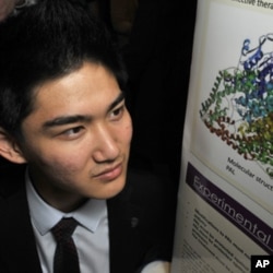 Jack Li poses with his poster board, which explains his research on a therapy for a rare genetic disease.