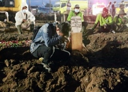 Putra Mardiansyah, 26, saat pemakaman ayahnya, Mustagor 59 tahun yang meninggal karena COVID-19, di area pemakaman yang disediakan pemerintah untuk para korban pandemi COVID-19 saat kasus melonjak, di Jakarta, 12 Juli 2021. (Foto: REUTERS/Ajeng Dinar Ulfi