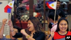 Filipinos cheer moments after the Hague-based U.N. international arbitration tribunal ruled in favor of the Philippines in its case against China on the dispute in South China Sea, July 12, 2016, in Manila, Philippines.