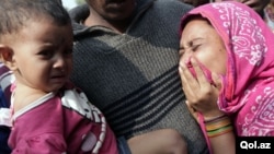 Relatives mourn the death of a garment worker after a fire consumed a garment factory in Savar, Bangladesh, November 25, 2012.