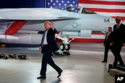 President Donald Trump waves as he walks off after participating in a roundtable discussion on tax policy at the Boeing Company, March 14, 2018, in St. Louis.
