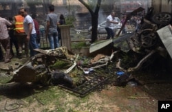 FILE - In this photo released by the Syrian official news agency SANA, Syrian citizens and firefighters gather where a rocket hit the Dubeet hospital in the central neighborhood of Muhafaza in Aleppo, Syria, May 3, 2016.