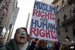 A demonstrator holds a sign during a rally outside Trump Tower in New York on Saturday, Nov. 12, 2016, to protest against President-elect Donald Trump.