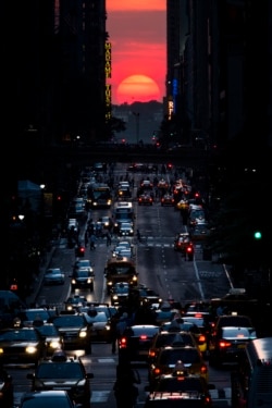 FILE - The sun sets along 42nd Street in Manhattan on May 29, 2013, in New York. (AP Photo/John Minchillo)
