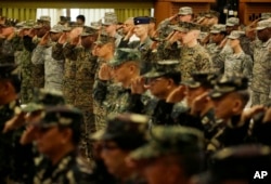 FILE - U.S. and Philippine troops salute during the opening ceremony of their joint military exercise dubbed "Balikatan 2015" at Camp Aguinaldo at suburban Quezon city, northeast of Manila, Philippines, April 20, 2015.