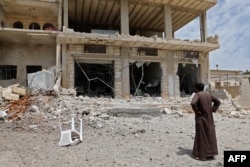 A man stares at a building damaged during reported shelling by government and allied forces, in the town of Hbeit in the southern countryside of the rebel-held Idlib province, Syria, May 3, 2019.