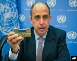FILE - Tomas Ojea Quintana, the U.N. special investigator on human rights in North Korea, holds up a lock given to him by North Koreans who escaped from the country, during a press conference, Oct. 23, 2018, at U.N. headquarters in New York.