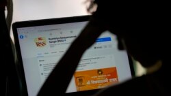 FILE - A girl looks at a Facebook page in New Delhi, Oct. 24, 2021.