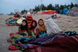 Anak-anak pengungsi Afghanistan menyelimuti tubuh mereka dengan selimut sementara cuaca musim dingin mulai melanda kamp pengungsi di Herat (foto: dok).