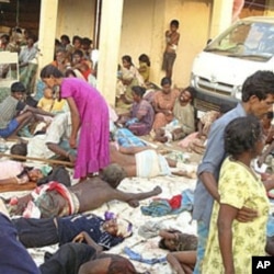 Sri Lankan ethnic Tamil victims of a shell attack wait outside a makeshift hospital in Tiger controlled No Fire Zone in Mullivaaykaal, May 10, 2009