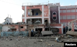 Somali policemen hold their positions during a firefight with Islamist al Shabaab gunmen outside a hotel in Somalia's capital Mogadishu, Nov. 1, 2015.