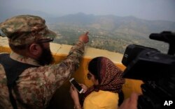 A Pakistan army officer points out the Indian forward area posts to journalists at Bagsar post on the Line of Control that divides Kashmir between Pakistan and India, on October 1, 2016. According to a report, Prime Minister Nawaz Sharif urged spy chief Rizwan Akhtar to take action in the region against three militant groups dedicated to fighting Indian forces.