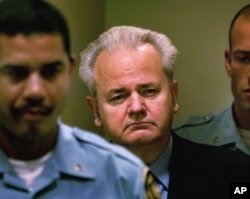 FILE - Slobodan Milosevic, center, enters the courtroom to appear before the court of the International Criminal Tribunal for the former Yugoslavia in The Hague, the Netherlands, Dec. 11, 2001.